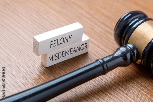 A judge’s gavel next to wooden blocks labeled Felony and Misdemeanor. Legal terms, criminal charges, and judicial concepts in law and justice concept.