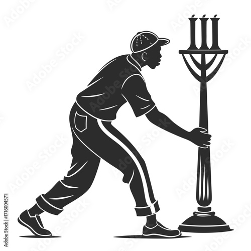 Silhouette of a man in a cap and casual clothes installing or adjusting a decorative street lamp