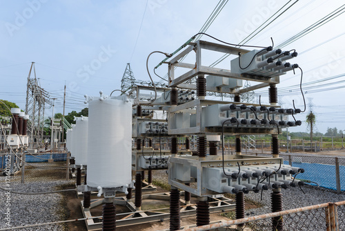 Photos Close-up view of outdoor high voltage capacitor bank with cylindrical reactors and stacked capacitor units, used for reactive power compensation and voltage stability in substations