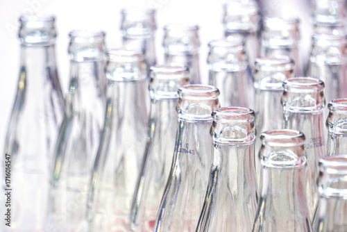 Many empty glass bottles are stacked together.