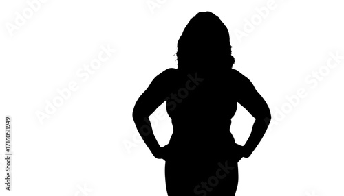 Confident woman stands with hands on hips exuding strength and empowerment in a bold silhouette ready for any challenge or project