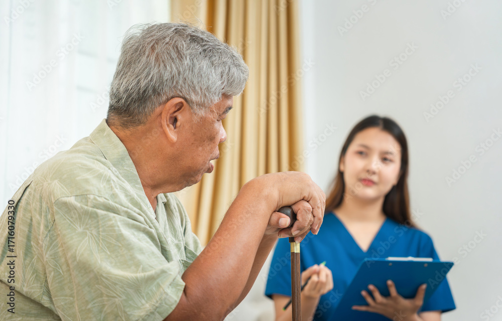 Obraz premium Senior Man with Cane Discussing Health with a Female Caregiver, Asian Elderly Man Holding Walking Stick During a Home Visit by a Nurse, Patient and a Medical Professional in a Consultation