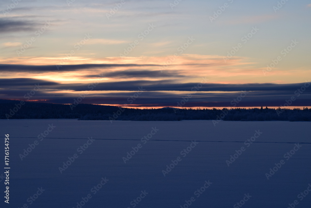 Fototapeta premium On a frosty winter evening we meet the sunset on the lake.