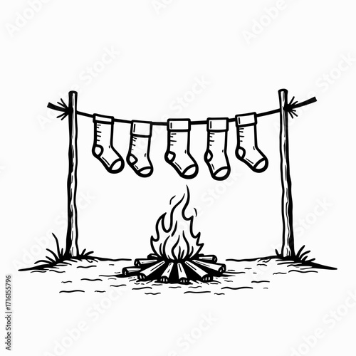 Socks drying over campfire on clothesline in outdoor setting  