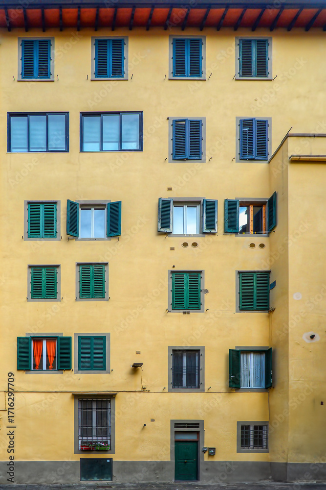 Fototapeta premium Facade of a traditional Italian residential building with multiple windows and shutters