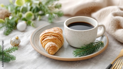 Enjoy a cozy morning with a cup of freshly brewed coffee and a flaky croissant, perfect for a delightful breakfast or brunch experience surrounded by greenery and soft fabrics.