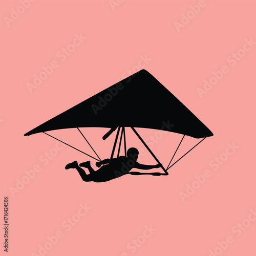 Silhouette of a person hang gliding with a triangular wing against a solid pink background in flight