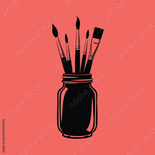 Black silhouette of various paintbrushes standing upright inside a glass jar on a solid coral background