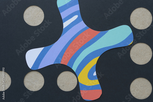 abstract paper background featuring a quatrefoil machine-cut shape black paper with circle cutouts and brown texture