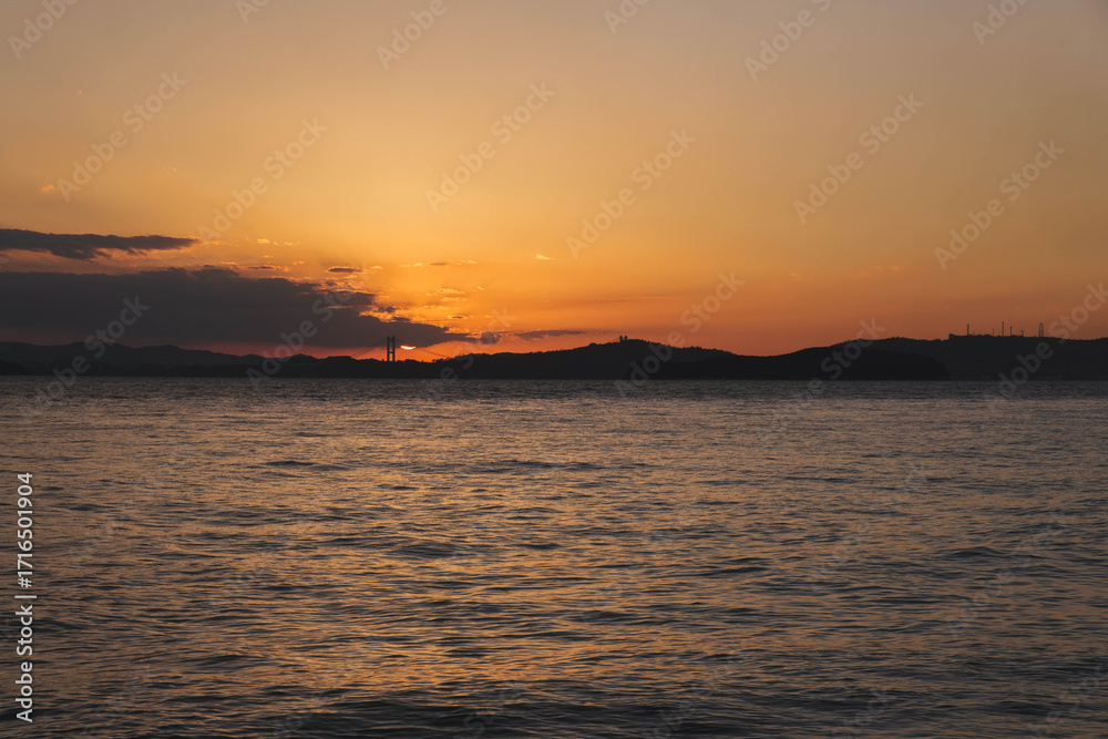 Fototapeta premium 渋川海岸、美しい夕日が海岸線に沈む風景、岡山、日本