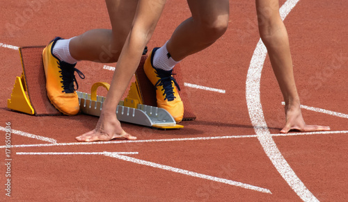 Close-up Of A Runner's Legs And Hands In A Starting Block, Poised And Ready To Begin A Race