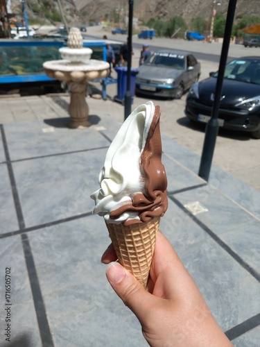 White ice cream & chocolate  on hand of a man in the side of the road 