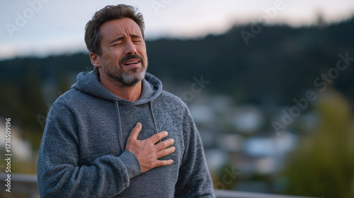 Middle-aged man standing outdoors clutching chest, eyes closed in agony, shallow depth of field isolating his emotional struggle