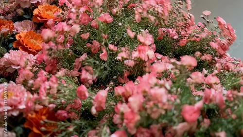 An anonymous figure in a black mask and floral dress sits engulfed by an overwhelming wall of flowers. A surreal, beautiful, and melancholic art concept.