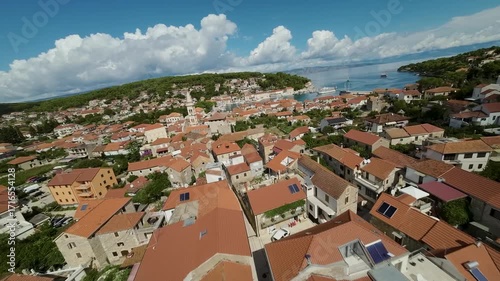 FPV aerial of Jelsa on Hvar island, Croatia. Town with red rooftops, bell tower and harbor seen from drone.