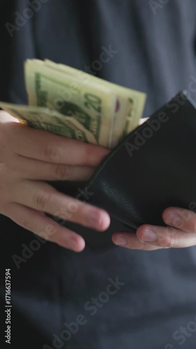Man in Black T-Shirt Taking Money Out of a Stolen Wallet
