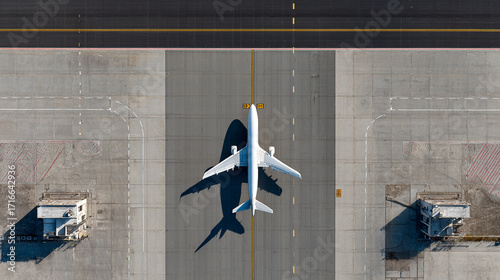 Airplane on airport tarmac top view shadow visible runway taxiway
