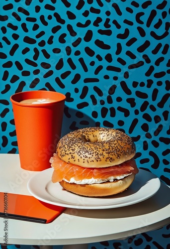 Fresh Bagel With Salmon and Lettuce Served With Orange Cup of Drink.