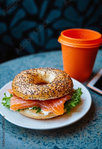 Fresh Bagel With Salmon and Lettuce Served With Orange Cup of Drink
