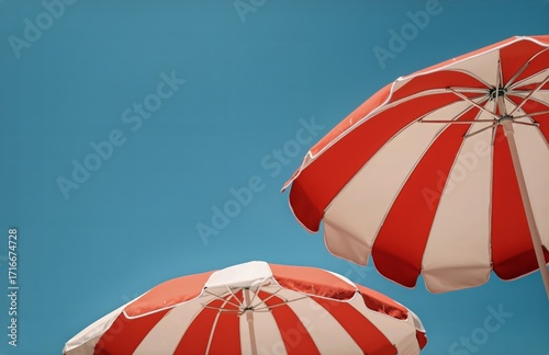 Bright Red and White Beach Umbrellas Against a Clear Blue Sky on a Sunny Summ...