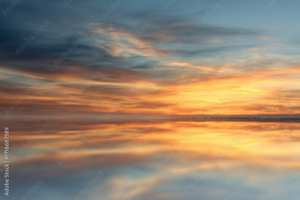 Fototapeta premium pristine floor mirror reflecting expansive sky essence of clouds at sunset
