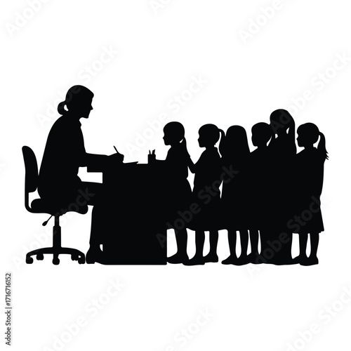 Teacher instructing young students at desk classroom