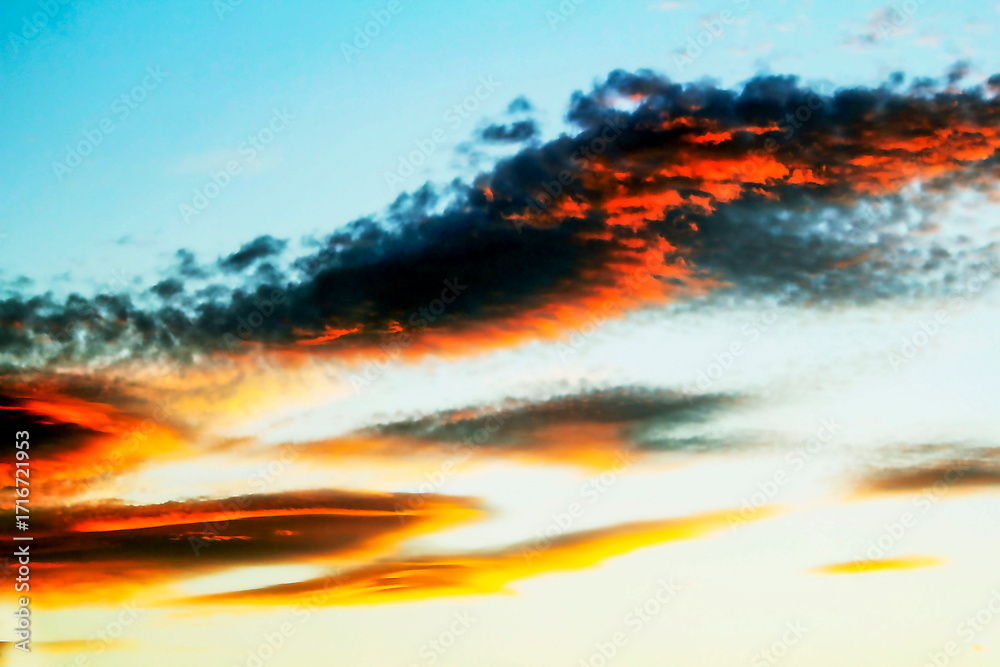 Fototapeta premium A breathtaking sunset painting the sky with fiery hues and dramatic clouds