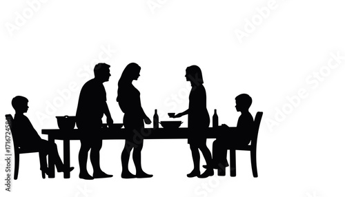 Silhouettes of family gathered around table during dinner time  