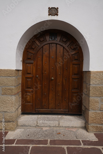 Porte ancienne brune entourée de pierre