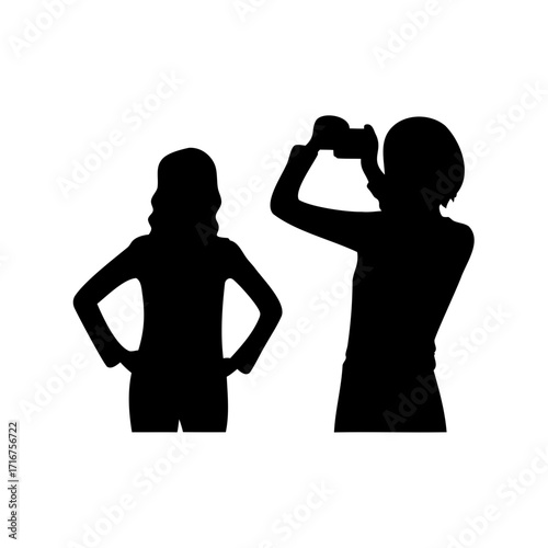 Silhouette of two women, one posing with a camera and the other standing