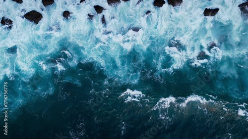 Wave crests and white foam forming abstract shapes, aerial top-down. Ocean surface background for editors