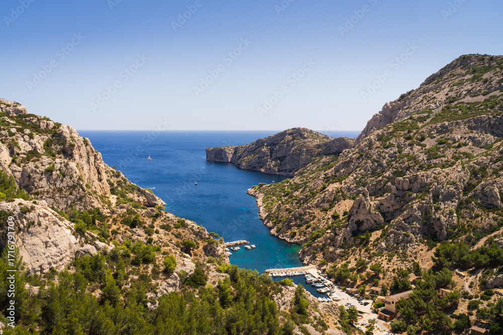 Fototapeta premium Breathtaking summer view of the Calanques National Park near Marseille, a rocky coastal inlet with boats in turquoise water.