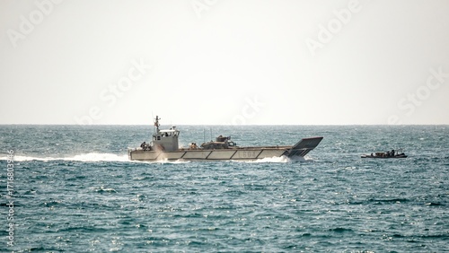Two military landing craft speed across the sea during naval amphibious training exercises