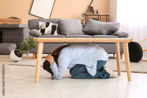 Young woman hiding under ta...