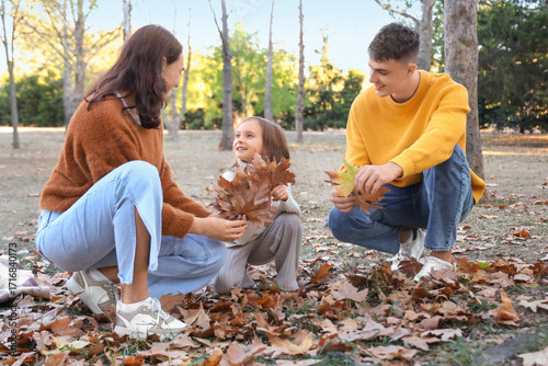 Happy family collecting lea...