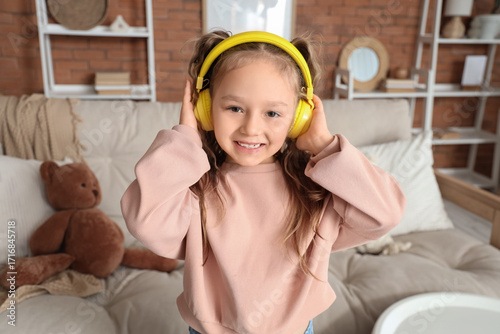 Cute little girl in headpho...