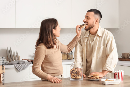 Young couple eating cookie ...