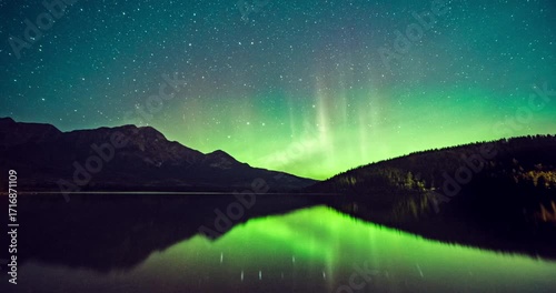 Time lapse of Aurora, northern lights glowing over pine forest at Pyramid Lake located at the foot of Pyramid Mountain in Jasper National Park, Alberta, Canada.