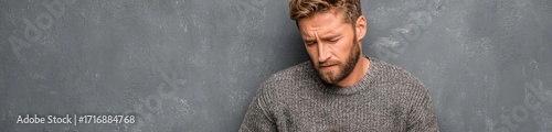 Man with stomach ulcer and pain on gray concept. A man looks distressed, holding his chest with a pained expression.