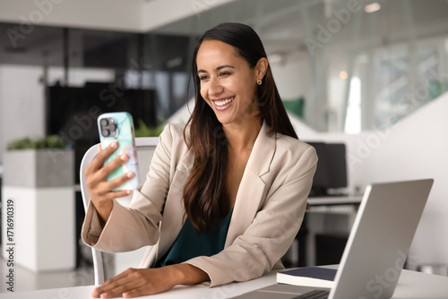 Cheerful beautiful Maori business woman talking on video call