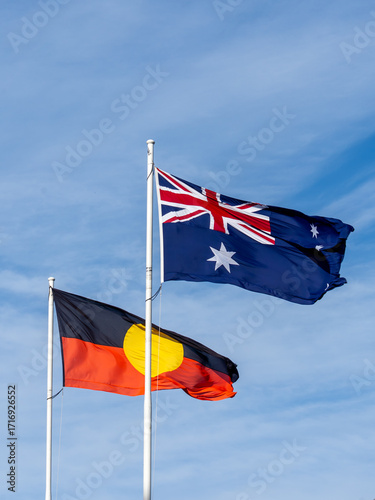 Australian national flag and Flag of Australian Aboriginal People waving with blue sky in the background 