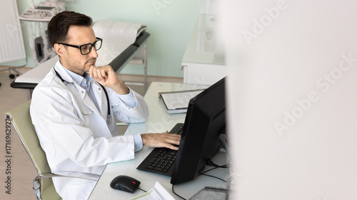 Wallpaper Mural Thoughtful male doctor sit at workplace look at pc screen Torontodigital.ca