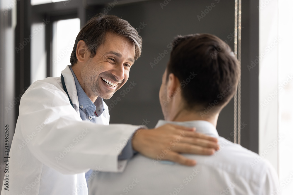 Fototapeta premium Happy doctor hold hand on patient back greet with recovery