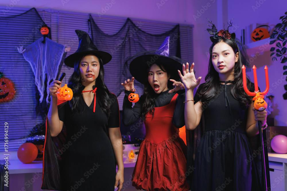 Obraz premium Young women celebrating halloween in witch costumes