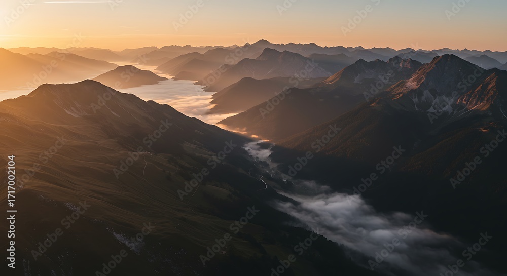 Naklejka premium Aerial View of Mountain Range with Misty Valleys