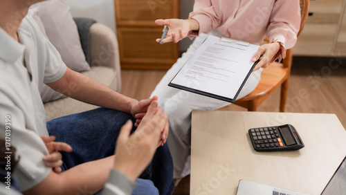 Φωτογραφία Asian adult woman insurance agent explaining health policy benefits client home