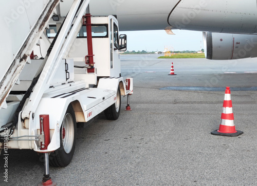 Airport ground handling equipment prepares for passenger boarding at busy terminal