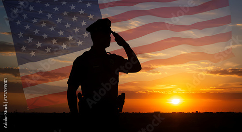Silhouette of a police officer saluting the american flag at sunset with a vibrant sky
