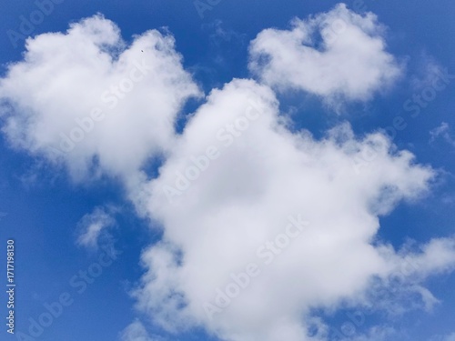 Clear blue sky with soft white clouds, ideal for use in design, wallpaper, and creative backgrounds.