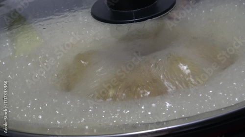 Foam bubbly soup in hot pot close up shot.